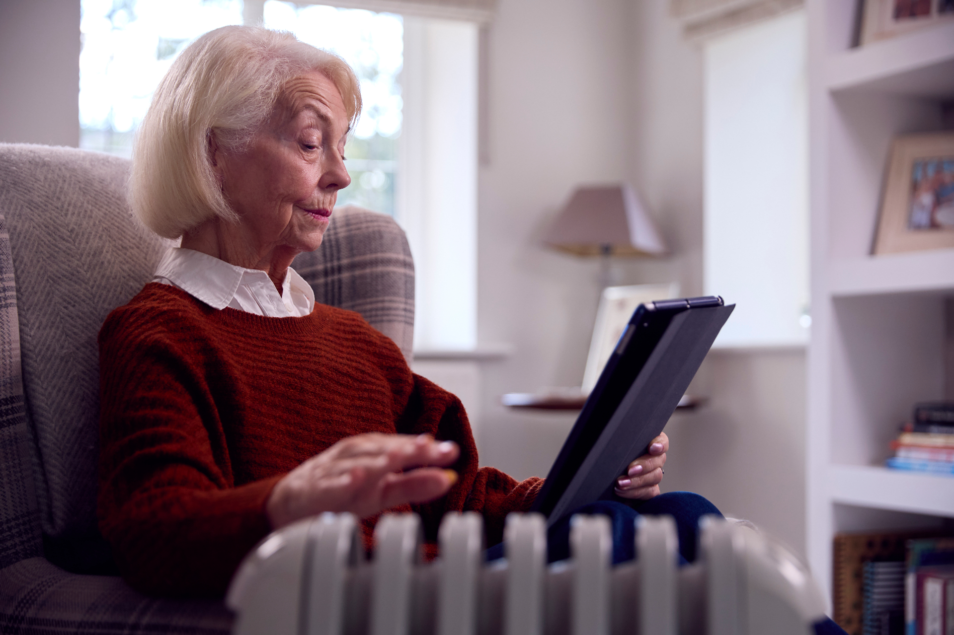 An elderly man reading comfortably in his own home